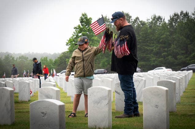 May 23, 2026, Canton, Georgia, USA: A father and son join scores of volunteers to place U.S. flags on veteransÃ¢â‚¬â ¢ graves during Memorial Day celebration at the Georgia National Cemetery. Canton USA - ZUMAn03_ 20260523_zaf_n03_004 Copyright: xRobinxRaynex