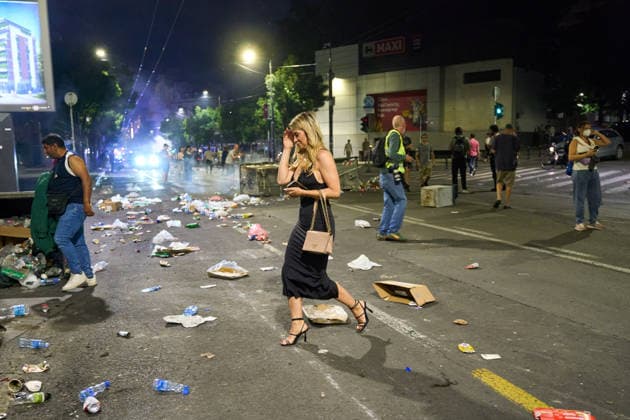 May 23, 2026, Belgrade, Central Serbia, Serbia: A large number of citizens answer the call of university students and gather to protest in the center of Belgrade. An elegantly dressed woman on a night out walks past garbage and debris left on the street after the protest. Belgrade Serbia  - ZUMAd223 20260523_zip_d223_019 Copyright: xMarkoxDimicx