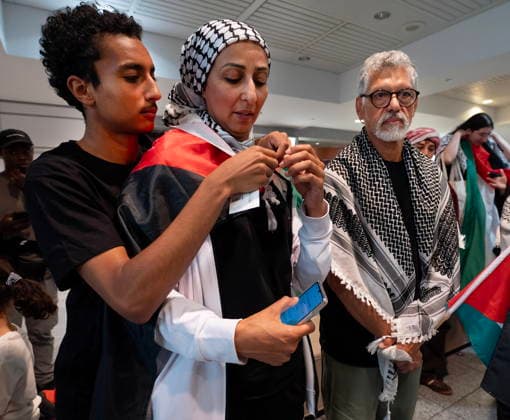 May 23, 2026, Montreal, Pq, CANADA: Safa Chebbi, left, and Ehab Lotayef, right, stand as Chebbi s son wraps her in a Palestinian flag as they arrive back at Montreal s Trudeau International Airport on Saturday, May 23, 2026. Chebbi and Lotayef were two of the 12 Canadians who were on board a flotilla trying to reach Gaza and spent four days in Israeli captivity. Montreal CANADA  - ZUMAc35_ 20260523_zaf_c35_156 Copyright: xPeterxMccabex