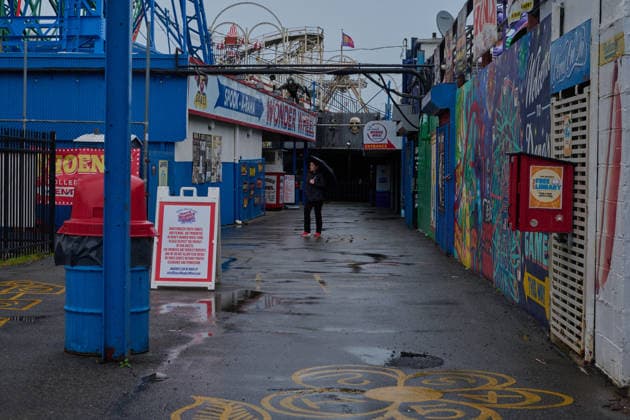 May 23, 2026, New York, New York, USA: A woman walks through DenoÃ¢â‚¬â ¢s Wonder Wheel amusement park in the rain with an umbrella on the day of the official opening of the 2026 Summer beach season in Coney Island, Brooklyn. New York USA  - ZUMAl171 20260523_znp_l171_003 Copyright: xEdnaxLeshowitzx