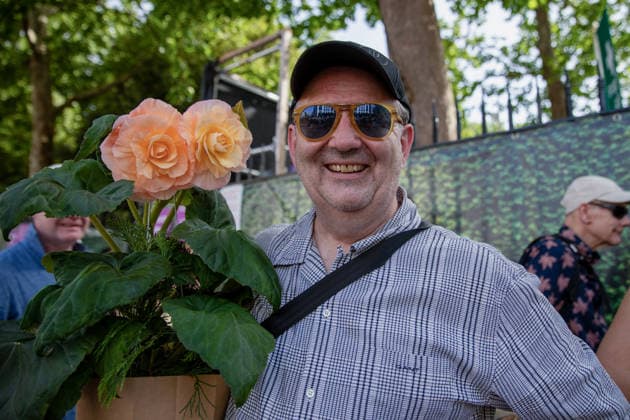 May 23, 2026, London, United Kingdom: A visitor to the last day of the RHS Chelsea Flower Show stands holding an orange flowering plant. Members of the public leave the Chelsea Flower Show carrying flowers, plants, and garden ornaments purchased from the exhibition displays on the event™s final day. As the famous horticultural showcase drew to a close, visitors were seen transporting blooms, shrubs and decorative items through the streets of Chelsea after buying pieces from the award-winning gardens and floral exhibits. London United Kingdom - ZUMAs197 20260523_aaa_s197_509 Copyright: xJamesxWilloughbyx