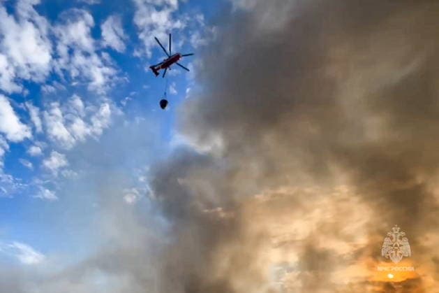 RUSSIA, MOSCOW - MAY 24, 2026: This video screen grab shows a firefighting helicopter at the scene of a fire at the Topolyok Market. The fire covered an area of 1,50o sq meters. The fire crews contained the fire. Video grab. Best possible quality. Russian Emergencies Ministry TASS  92988058