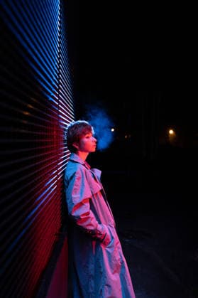 Eine verängstigte, verlassene Frau stand in neonfarbenem Licht an einer Wand, während sie in der kalten Nacht auf der Straße stand. Thoughtful unhappy young female stands on dark street illuminated by coloured neon light. Distant dismayed millennial girl in depression stands alone near wall thinks about life at cold weather night (License=RF) ,model released, Symbolfoto Copyright: xZoonar.com DmitriixMarchenkox xEnvatox 25067597 ,model released, Symbolfoto ,property released