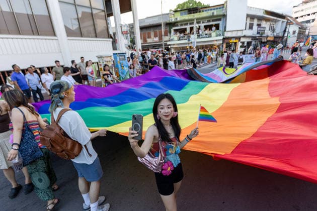 May 24, 2026, Chiang Mai, Thailand: A participant holds a rainbow flag and takes a selfie during The Chiang Mai Pride Parade 2026 celebrations. The Chiang Mai Pride Parade 2026 took place in Chiang Mai, Thailand. Chiang Mai province holds Thailandis first Pride Month celebrations annually, promoting gender equality, diversity, and human rights as part of Pride Month activities in northern Thailand. Chiang Mai Thailand  - ZUMAs197 20260524_aaa_s197_133 Copyright: xPongmanatxTasirix