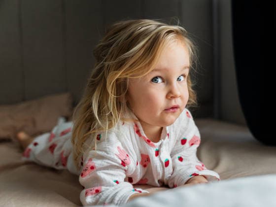 Toddler girl in pajamas lying on bed, looking at camera Antalya, Antalya, Türkiye CR_BMEE260513-2016014-01 ,model released, Symbolfoto