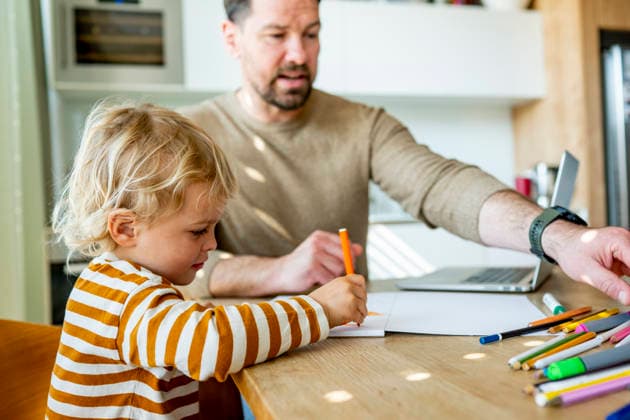 Remote working dad taking care of ill child during home office day. Father working from home while caring for sick toddler staying home from daycare. model released