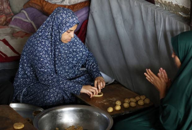 Palestinian women bake Eid cakes inside shelter in Gaza City Palestinian women prepare and bake traditional Eid cakes on makeshift ovens inside a shelter near the Yellow Line area east of Gaza City on May 25, 2026, ahead of Eid al-Adha. Displaced residents are attempting to preserve holiday traditions despite the harsh humanitarian conditions facing Palestinians in the Gaza Strip. Photo by Bilal Osama apaimages Gaza city Gaza Strip Palestinian Territory 250526_Gaza_BO_00(10) Copyright: xapaimagesxBilalxOsamax xapaimagesx