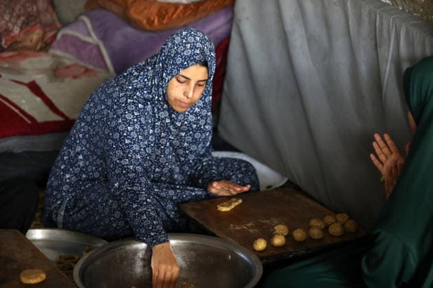 Palestinian women bake Eid cakes inside shelter in Gaza City Palestinian women prepare and bake traditional Eid cakes on makeshift ovens inside a shelter near the Yellow Line area east of Gaza City on May 25, 2026, ahead of Eid al-Adha. Displaced residents are attempting to preserve holiday traditions despite the harsh humanitarian conditions facing Palestinians in the Gaza Strip. Photo by Bilal Osama apaimages Gaza city Gaza Strip Palestinian Territory 250526_Gaza_BO_00(11) Copyright: xapaimagesxBilalxOsamax xapaimagesx
