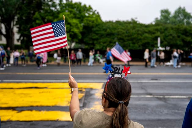 A woman waves a U.S. flag as the Memorial Day Parade passes down Constitution Avenue on Memorial Day in Washington, DC on Monday, May 25, 2026.  WAP20260525334 BONNIExCASH