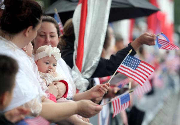May 25, 2026, Washington, District Of Columbia, USA: Attendees holding American flags watch the National Memorial Day Parade in Washington, DC, USA, on May 25, 2026. The parade has been held annually since 2005, marking its 21st anniversary. Washington USA  - ZUMAs337 20260525_znp_s337_005 Copyright: xGentxShkullakux