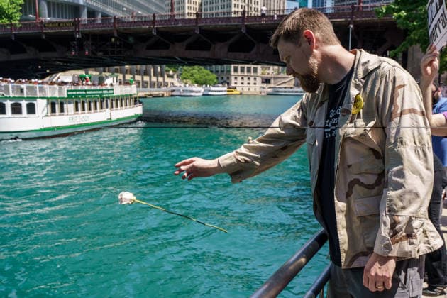 May 25, 2026, Chicago, Illinois, USA: Army Veteran AARON HUGHES throws a flower into the Chicago River during a Memorial Day protest of veterans against war, organized by About Face at the Vietnam Memorial Fountain on Chicago s Riverfront Chicago USA - ZUMAr170 20260525_znp_r170_006 Copyright: xChrisxRihax