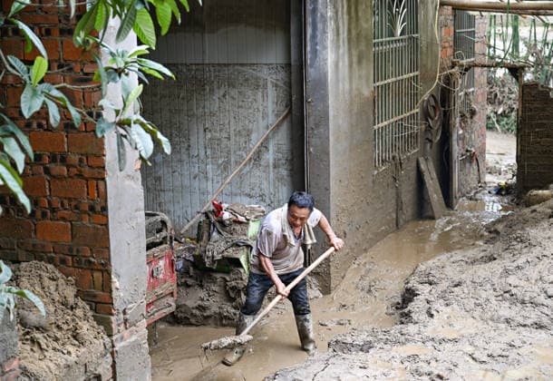(260526) -- CHONGQING, May 26, 2026 -- A villager cleans up silt-covered livestock enclosure at Daqiao Village of Yongchuan District, southwest China s Chongqing Municipality, May 26, 2026. From Saturday night to early Sunday morning, a sudden and extreme catastrophic rainstorm struck Yongchuan, triggering flash floods and geological disasters in multiple areas of this district. After the disaster occurred, the local authorities immediately activated the emergency response mechanism, coordinated rescue forces from all sides and made every effort to carry out rescue operations and infrastructure restoration. Rescue and response efforts are still underway. ) CHINA-CHONGQING-FLOOD-RESCUE (CN) WangxQuanchao 