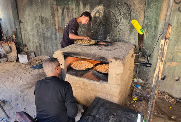 Displaced Palestinian family bakes Eid cakes inside shelter in Khan Younis A displaced Palestinian family prepares and bakes traditional Eid cakes on makeshift ovens inside a tent at a shelter center in Khan Younis in the southern Gaza Strip on May 26, 2026, ahead of Eid al-Adha. Palestinian families are trying to preserve holiday traditions and bring joy to children despite the ongoing war and harsh living conditions. Photo by Tariq Mohammad APA Images Khan Yunis Gaza Strip Palestinian Territory 260526_Khan_Yunis_TM_02(27) Copyright: xapaimagesxTariqxMohammad xapaimagesx