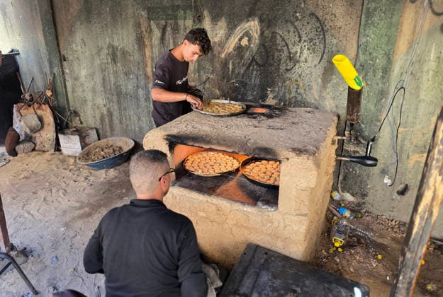 Displaced Palestinian family bakes Eid cakes inside shelter in Khan Younis A displaced Palestinian family prepares and bakes traditional Eid cakes on makeshift ovens inside a tent at a shelter center in Khan Younis in the southern Gaza Strip on May 26, 2026, ahead of Eid al-Adha. Palestinian families are trying to preserve holiday traditions and bring joy to children despite the ongoing war and harsh living conditions. Photo by Tariq Mohammad APA Images Khan Yunis Gaza Strip Palestinian Territory 260526_Khan_Yunis_TM_02(28) Copyright: xapaimagesxTariqxMohammad xapaimagesx