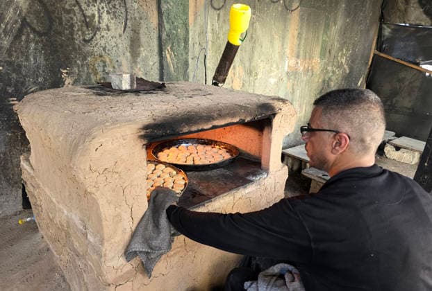 Displaced Palestinian family bakes Eid cakes inside shelter in Khan Younis A displaced Palestinian family prepares and bakes traditional Eid cakes on makeshift ovens inside a tent at a shelter center in Khan Younis in the southern Gaza Strip on May 26, 2026, ahead of Eid al-Adha. Palestinian families are trying to preserve holiday traditions and bring joy to children despite the ongoing war and harsh living conditions. Photo by Tariq Mohammad APA Images Khan Yunis Gaza Strip Palestinian Territory 260526_Khan_Yunis_TM_02(34) Copyright: xapaimagesxTariqxMohammad xapaimagesx
