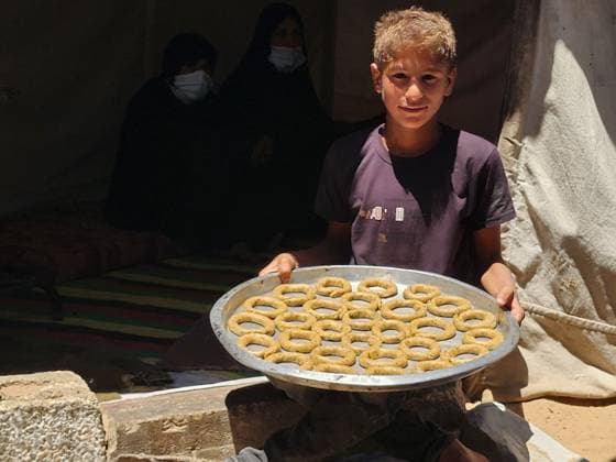 Eid traditions continue to be kept alive in Gaza KHAN YUNIS, GAZA, PALESTINE - MAY 26: A boy holds a tray of cookies as preparations for Eid al-Adha continue in Khan Yunis, Gaza, Palestine, on May 26, 2026. Palestinian women are trying to keep the traditions alive under difficult conditions by preparing traditional Eid cookies made with dates and in ring shapes. Hani Alshaer Anadolu Khan Yunis Gaza. Editorial use only. Please get in touch for any other usage.  Copyright: x2026xAnadoluxHanixAlshaerx