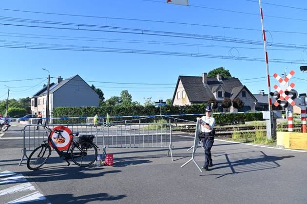 A police officer removes a barrier to clear the way for traffic on the scene of an accident between a train and a minivan, at the railway crossing Vierhuizen, in Buggenhout, Tuesday 26 May 2026. The accident happened around 8:15 am. Four people have been killed, the driver, two children and their supervisor. According to initial reports, the level crossing was closed at the time of the accident.  EMILExWINDAL 175109381