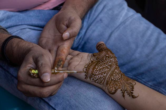 May 26, 2026, Srinagar, Jammu And Kashmir, India: A mehendi artist applies henna to a girlÃ¢â‚¬â ¢s hand at a market ahead of Eid al-Adha in Srinagar, the summer capital of Jammu and Kashmir. Srinagar India  - ZUMAf191 20260526_zip_f191_005 Copyright: xUmarxFarooqx