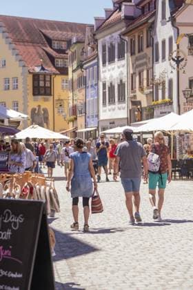 Belebte Fußgängerzone mit Menschen, flankiert von historischen Gebäuden und dekorativen Schildern, Wangen im Allgäu, Deutschland Lively pedestrian zone with people flanked by historic buildings and decorative signs, Wangen im Allgäu, Germany Copyright: imageBROKER ManuelxKamuf iblmlk17855941.jpg
