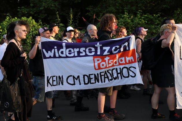 Demonstranten laufen mit Banner Widersetzen Potsdam Kein cm den Faschos in der Straße Alter Tornow auf der Halbinsel Hermannswerder während einer Demonstration gegen die Räumung des ehemals besetzten Hauses Tornowstraße 40, Potsdam, 26. Mai 2026. Hausbesetzer-Demo in Potsdam *** Demonstrators walk with banner Widersetzen Potsdam Kein cm den Faschos in the street Alter Tornow on the peninsula Hermannswerder during a demonstration against the eviction of the formerly squatted house Tornowstraße 40, Potsdam, May 26, 2026 Squatters demonstration in Potsdam