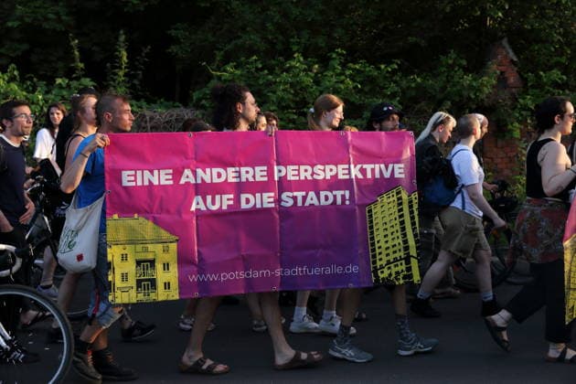 Demonstranten laufen mit Banner Eine andere Perspektive auf die Stadt! Stadt für alle in der Straße Alter Tornow auf der Halbinsel Hermannswerder während einer Demonstration gegen die Räumung des ehemals besetzten Hauses Tornowstraße 40, Potsdam, 26. Mai 2026. Hausbesetzer-Demo in Potsdam *** Demonstrators walk with banner A different perspective on the city City for all in the street Alter Tornow on the Hermannswerder peninsula during a demonstration against the eviction of the formerly squatted house Tornowstraße 40, Potsdam, May 26, 2026 Squatters demonstration in Potsdam