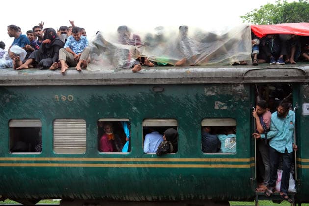 May 27, 2026, Joydevpu, Gazipur, Bangladesh: Ahead of Eid al-Adha, passengers traveling on the roof of an overcrowded train from Joydebpur in Gazipur, Bangladesh, cover themselves with plastic sheets to protect against heavy rain as they journey back to their village homes. Many of the passengers are low-income garment workers who endure these dangerous travel conditions due to the affordable fare. Joydevpu Bangladesh - ZUMAk174 20260527_zip_k174_011 Copyright: xSyedxMahabubulxKaderx