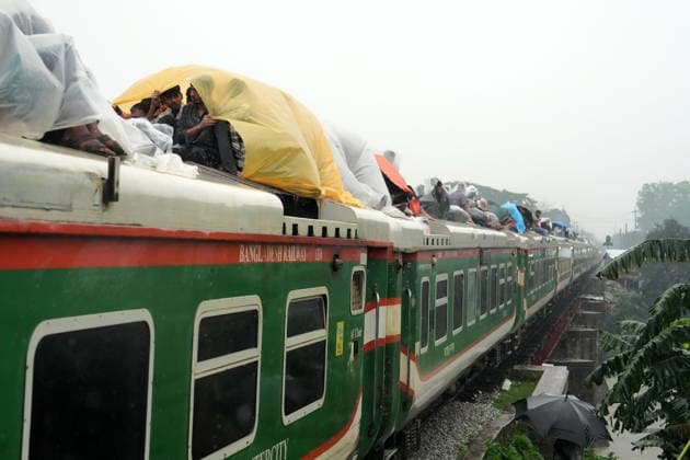 May 27, 2026, Joydevpu, Gazipur, Bangladesh: Ahead of Eid al-Adha, passengers traveling on the roof of an overcrowded train from Joydebpur in Gazipur, Bangladesh, cover themselves with plastic sheets to protect against heavy rain as they journey back to their village homes. Many of the passengers are low-income garment workers who endure these dangerous travel conditions due to the affordable fare. Joydevpu Bangladesh  - ZUMAk174 20260527_zip_k174_003 Copyright: xSyedxMahabubulxKaderx