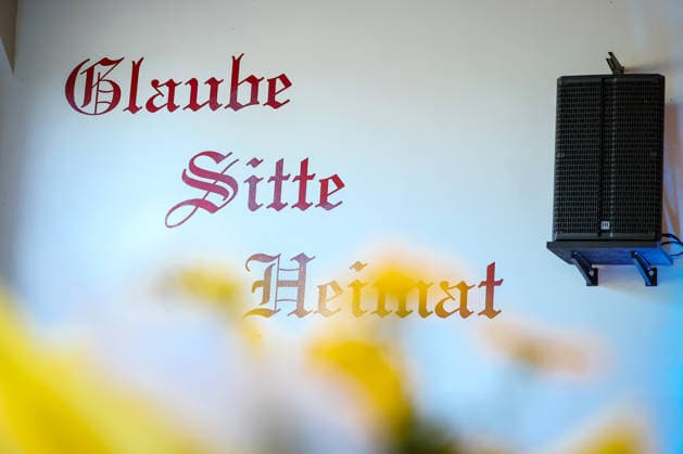 27.05.2026, Politik, Bundeskanzler Friedrich Merz (CDU) zu Gast als Festredner beim Festakt in der Schützenhalle Hüsten bei Arnsberg. 80 Jahre Neheim-Hüstener Programm. Wandaufschrift Schriftzug Glaube Sitte Heimat Nordrhein-Westfalen Deutschland *** 27 05 2026, Politics, Federal Chancellor Friedrich Merz CDU as guest speaker at the ceremony in the Schützenhalle Hüsten near Arnsberg 80 years Neheim Hüstener program wall inscription lettering faith custom home North Rhine-Westphalia Germany