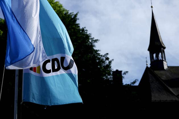 27.05.2026, Politik, Bundeskanzler Friedrich Merz (CDU) zu Gast als Festredner beim Festakt in der Schützenhalle Hüsten bei Arnsberg. 80 Jahre Neheim-Hüstener Programm. CDU-Fahne gegenüber einer Kirche Nordrhein-Westfalen Deutschland *** 27 05 2026, Politics, Federal Chancellor Friedrich Merz CDU as guest speaker at the ceremony in the Schützenhalle Hüsten near Arnsberg 80 years Neheim Hüstener program CDU flag opposite a church North Rhine-Westphalia Germany