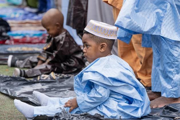 May 27, 2026, New York, New York, USA: A child seen playing as men pray with Mayor Zohran Mamdani during Eid Al-Adha holiday prayers at The Yancy Track & Field in New York, NY on May 27, 2026. Hundreds of men, women and children attended wearing clean, colorful and expensive traditional clothes. Eid al-Adha translates from Arabic to Festival of Sacrifice is one of the most important holidays in the Islamic calendar. It honors the Prophet Ibrahim s (Abraham s in Judaism) absolute obedience to God, commemorating his willingness to sacrifice his son as an act of submission before God provided a ram to sacrifice instead. New York USA  - ZUMAr339 20260527_znp_r339_049 Copyright: xLevxRadinx