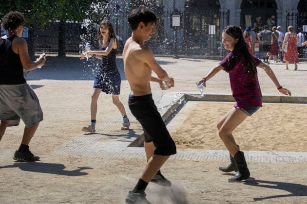 Paris, France May 27, 2026 - People have a water fight on Place des Vosges during the heat wave. Temperatures in the French capital are about 10 degrees higher than the seasonal average, with temperatures exceeding 30 degrees, reaching the threshold for a heat wave. METEO, CANICULE, FORTES CHALEURS, ILLUSTRATION, ESTIVAL, ESTIVALE, GENERIQUE, SOLEIL, TOURISME, SITE TOURISTIQUE, PARIS, VIGILANCE, VAGUE DE CHALEUR, CHANGEMENT CLIMATIQUE, PLACE DES VOSGES, JARDIN, PARC, JEUX, S AMUSER, BATAILLE D EAU  Copyright: xVincentxIsorex