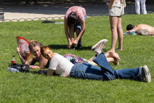 Paris, France May 27, 2026 - A person lays on the grass at Place des Vosges cools off with a fan during the heat wave .Temperatures in the French capital are about 10 degrees higher than the seasonal average, with temperatures exceeding 30 degrees, reaching the threshold for a heat wave. METEO, CANICULE, FORTES CHALEURS, ILLUSTRATION, ESTIVAL, ESTIVALE, GENERIQUE, SOLEIL, TOURISME, SITE TOURISTIQUE, PARIS, VIGILANCE, VAGUE DE CHALEUR, CHANGEMENT CLIMATIQUE, PLACE DES VOSGES, JARDIN, PARC,  Copyright: xVincentxIsorex