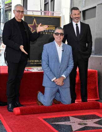 Comedy, actor, radio personality and television host Adam Corolla (kneeling) is joined by Dr. Drew Pinsky (L) and Jimmy Kimmel during an unveiling ceremony honoring him with the 2,846th star on the Hollywood Walk of Fame in Los Angeles on Wednesday, May 27, 2026.  LAP2026052702 JIMxRUYMEN