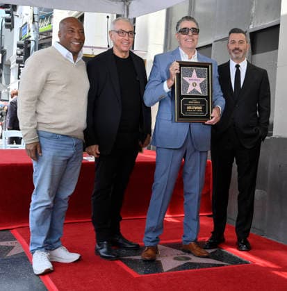 Comedy, actor, radio personality and television host Adam Corolla holds a replica plaque as he is joined by Byron Allen, Drew Pinsky, Joel McHale, and Jimmy Kimmel (L-R) during an unveiling ceremony honoring him with the 2,846th star on the Hollywood Walk of Fame in Los Angeles on Wednesday, May 27, 2026.  LAP2026052705 JIMxRUYMEN