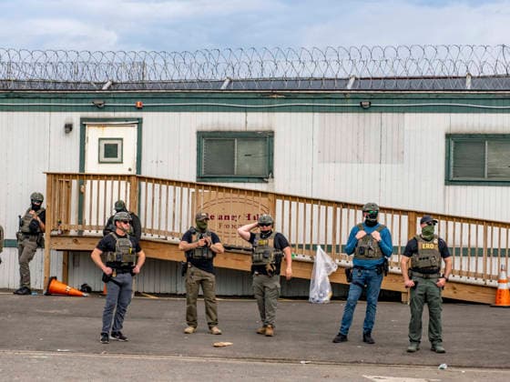 May 27, 2026, Newark, New Jersey, USA: ICE agents wearing bullet-proof vests stand outside of Delaney Hall ICE detention center, some posing for the camera, as detainees inside continue their hunger and labor strike over inhumane conditions and due process violations. Supporters of the detainees are nearby. Newark USA - ZUMAd155 20260527_znp_d155_015 Copyright: xSuexDorfmanx