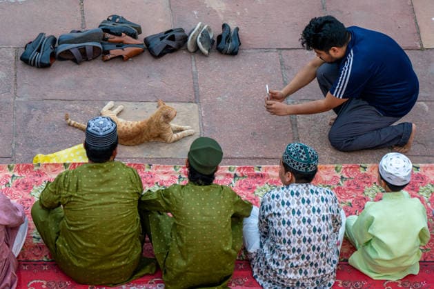 Eid al-Adha in India NEW DELHI, INDIA - MAY 28: Indian Muslims sit near a cat as a man takes photographs outside Jama Masjid during Eid al-Adha prayers in New Delhi, India, on May 28, 2026. Amarjeet Kumar Singh Anadolu New Delhi India. Editorial use only. Please get in touch for any other usage.  Copyright: x2026xAnadoluxAmarjeetxKumarxSinghx