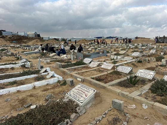 Eid Al Adha Cemetery Memorial Khan Yunis A view shows graves, as people gather to offer prayers during Eid al-Adha in the background, at a cemetery in Khan Yunis, Gaza Strip, on May 27, 2026. Eid al-Adha, or the Feast of Sacrifice, is one of the most important holidays in the Islamic calendar, commemorating the willingness of Prophet Ibrahim to sacrifice his son. The event is traditionally marked worldwide by communal prayers, family gatherings, acts of charity, and the slaughtering of livestock. In Gaza, the ongoing conflict has significantly impacted traditional observances, leading to residents substituting fresh livestock with frozen meat and visiting the graves of those killed during the war. Khan Yunis Gaza Strip Palestinian Territori Copyright: xDoaaxAlbazx