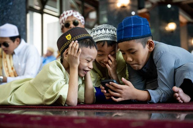 Eid al-Adha in Thailand BANGKOK, THAILAND - MAY 28: Kids play on a mobile phone between prayers. Thai Muslims pray during Eid al-Adha at Masjid Buddarul Mumineen mosque in Bangkok, Thailand on May 28, 2026. Matt Hunt Anadolu Bangkok Thailand. Editorial use only. Please get in touch for any other usage.  Copyright: x2026xAnadoluxMattxHuntx