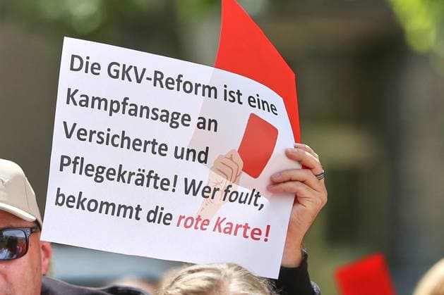 Berlin, Deutschland, 28.05.2026: Lichtenberg: Verdi-Protest gegen die geplante Krankenkassenreform: Protestler halten ein Schild mit der Aufschrift: Die GKV-Reform ist eine Kampfansage an Versicherte und Pflegekräfte! Wer foult, bekommt die rote Karte! hoch. Am Sana Klinikum Lichtenberg findet die Aktion Rote Karten für Frau Warken statt. *** Berlin, Germany, 28 05 2026 Lichtenberg Verdi protest against the planned health insurance reform Protesters hold a sign with the inscription Die GKV Reform ist eine Kampfansage an Versicherte und Pflegekräfte Wer foult, bekommt die rote Karte hoch At the Sana Klinikum Lichtenberg the action Rote Karten für Frau Warken takes place Copyright: xdtsxNachrichtenagenturx dts_121071