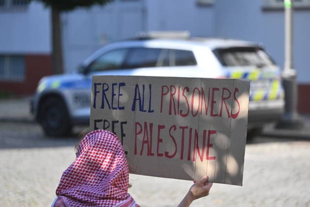 The situation in front of the District Court in Pardubice, where a custody hearing is underway with a man accused of intentionally setting fire to the LPP Holding hall, 28 May 2026, Pardubice, Czech Republic. Several supporters, including girls, came to support the detainee in front of the court building with Palestinian scarves and banners. Criminal investigators are accusing him of the crime of a terrorist attack and participation in a terrorist group. According to earlier reports, police have detained ten people in connection with this case. A fire broke out on March 20 in the production hall of the LPP Holding arms factory in Pardubice. The Earthquake Faction alleged anti-Israel group claimed responsibility for the fire. The group state  CTKPhotoP2026052807565