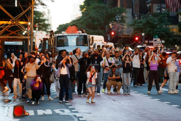 Revelers holding cameras and cell phones stand on 42nd street with moving traffic for a Manhattanhenge sunset event in New York City on Thursday, May 28, 2026. The Manhattanhenge sunset comes twice a year when the setting sun aligns precisely with Manhattan s street grid.  NYP20260528209 JohnxAngelillo