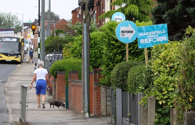 May 29, 2026, Makerfield, Greater Manchester, UK: Makerfield, UK. A woman walks her dog past Reform Uk campaign placards in Ashton-In-Makerfield, Greater Manchester, ahead of the Makerfield by-election which takes place on the 18th June. Makerfield UK  - ZUMAl94_ 20260529_zaf_l94_002 Copyright: xJacquelinexLawriex