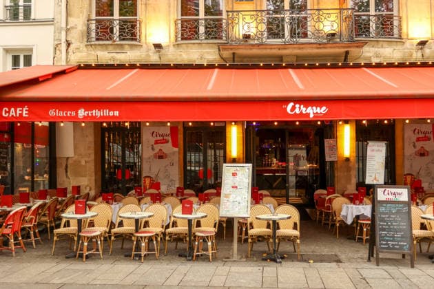 Paris, Frankreich. 13. Oktober 2025. Ein traditionelles französisches Café in Paris mit einer roten Markise, das Touristen zum Verweilen einlädt Paris, France. October 13, 2025. Parisian street cafe featuring a classic red awning and outdoor seating area for customers (License=RM) Copyright: xZoonar.com VolhaxHalkouskayax 25106937