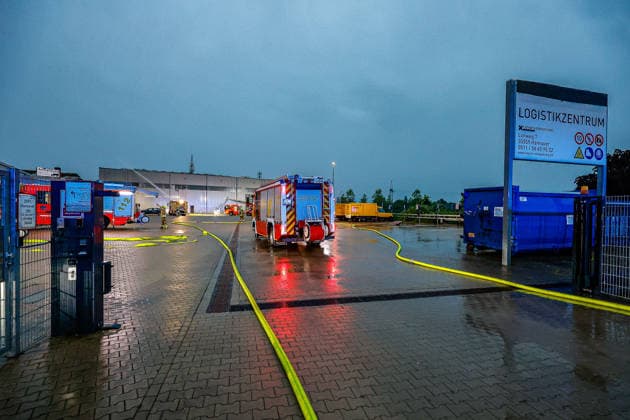 Großbrand in einer Lager- und Logistikhalle Haupteinfahr zur Lagerhalle, Löschfahrzeuge und Drehleiter der Feuerwehr Hannover im Hintergrund Hannover-Anderten Lohweg 7, Gewerbegebiet Niedersachsen, Region Hannover Germany *** Major fire in a warehouse and logistics hall Main entrance to the warehouse, fire engines and turntable ladder of the Hanover fire department in the background Hanover Anderten Lohweg 7, Lower Saxony industrial estate, Hanover region Germany