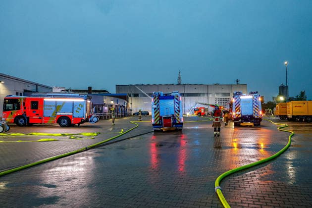 Großbrand in einer Lager- und Logistikhalle Haupteinfahr zur Lagerhalle, Löschfahrzeuge und Drehleiter der Feuerwehr Hannover im Hintergrund Hannover-Anderten Lohweg 7, Gewerbegebiet Niedersachsen, Region Hannover Germany *** Major fire in a warehouse and logistics hall Main entrance to the warehouse, fire engines and turntable ladder of the Hanover fire department in the background Hanover Anderten Lohweg 7, Lower Saxony industrial estate, Hanover region Germany