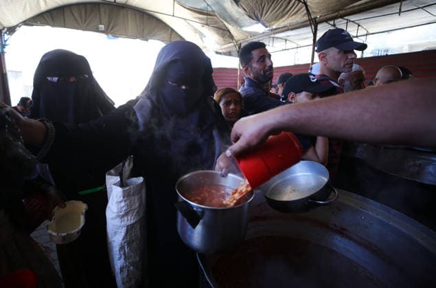 Displaced Palestinians Queue for Free Meals in Nuseirat Camp Displaced Palestinian children and women stand in line to receive free meals from a charity kitchen during the Eid al-Adha holiday in Nuseirat refugee camp, central Gaza Strip, on May 30, 2026. Displaced families in the Gaza Strip continue to rely on community kitchens and humanitarian assistance to meet their basic food needs amid ongoing humanitarian challenges. Hassan Jedi apaimages Nusairat Gaza Strip Palestinian Territory 300526_Nusairat_HJ_00(8) Copyright: xapaimagesxHassanxJedix xapaimagesx