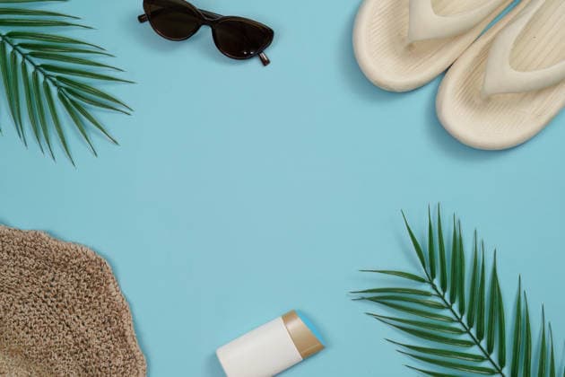 Sommerurlaub-Flatlay mit Sonnenbrille, Flip-Flops und Palmblättern A vibrant flat lay of summer vacation items including sunglasses, flip flops, and palm leaves on a light blue background. (License=RF) Copyright: xZoonar.com WORAWEExMEEPIANx 25112671