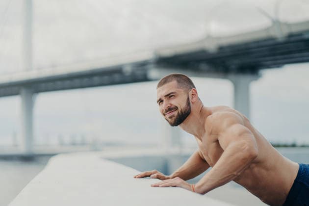 Ein athletischer Mann ohne Hemd macht Liegestütze an einem Geländer im Freien, im Hintergrund sind eine Brücke und ein Fluss zu sehen Shirtless athletic man doing incline push-ups on outdoor railing with bridge and river in background (License=RF) ,model released, Symbolfoto Copyright: xZoonar.com ViorelxKurnosovx 25125171 ,model released, Symbolfoto ,property released