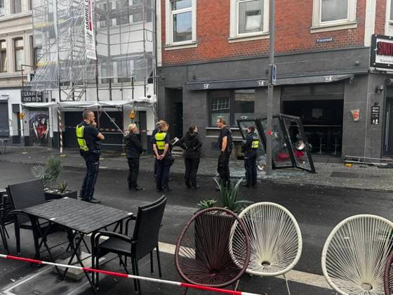 Polizisten und Ermittler stehen vor einer Bar mit zerstörter Glasscheibe am Friesenwall in Köln. Die Straße wurde abgesperrt, im Vordergrund sind Stühle eines CafÃ s zu sehen. Friesenwall, Köln, Deutschland *** Police officers and investigators stand in front of a bar with a destroyed glass pane on Friesenwall in Cologne The street has been cordoned off, chairs from a café can be seen in the foreground Friesenwall, Cologne, Germany