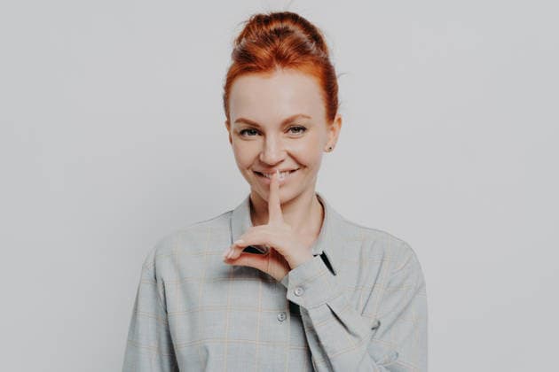 Fröhliche junge rothaarige Frau in den Dreißigern, die eine ?Pst?-Geste macht, während sie isoliert vor einem grauen Studiohintergrund posiert Sign of silence. Headshot portrait of cheerful young ginger 30s woman showing hush gesture, keeping finger on lips while posing isolated on grey studio background. Privacy and silence concept (License=RF) ,model released, Symbolfoto Copyright: xZoonar.com ViorelxKurnosovx 25127766 ,model released, Symbolfoto ,property released